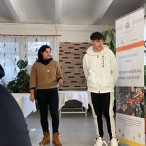 Tineri și elevi colaborând la calculatoare în cadrul unui atelier digital educativ